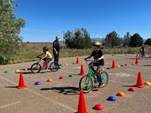 kids on bikes ride through obstacle course