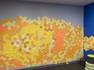 hundreds of yellow- and gold-colored hexagons on the wall with Summer Reading minutes on each one.