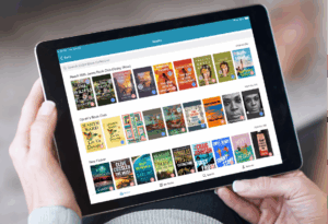 person holding a tablet displaying a selection of books on CloudLibrary.